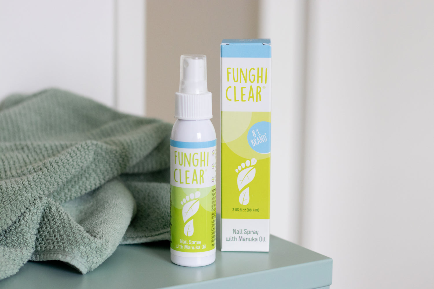 FunghiClear® nail spray with Manuka oil shown next to its packaging for toenail fungus care